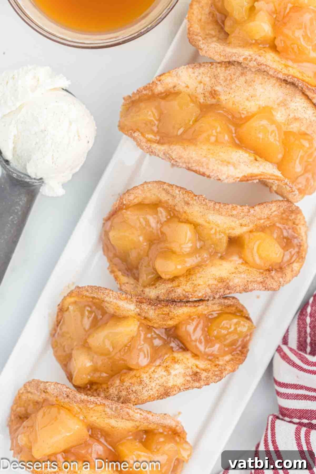 Crispy Apple Pie Wraps 2 Apple Pie Tacos topped with ice cream on a plate