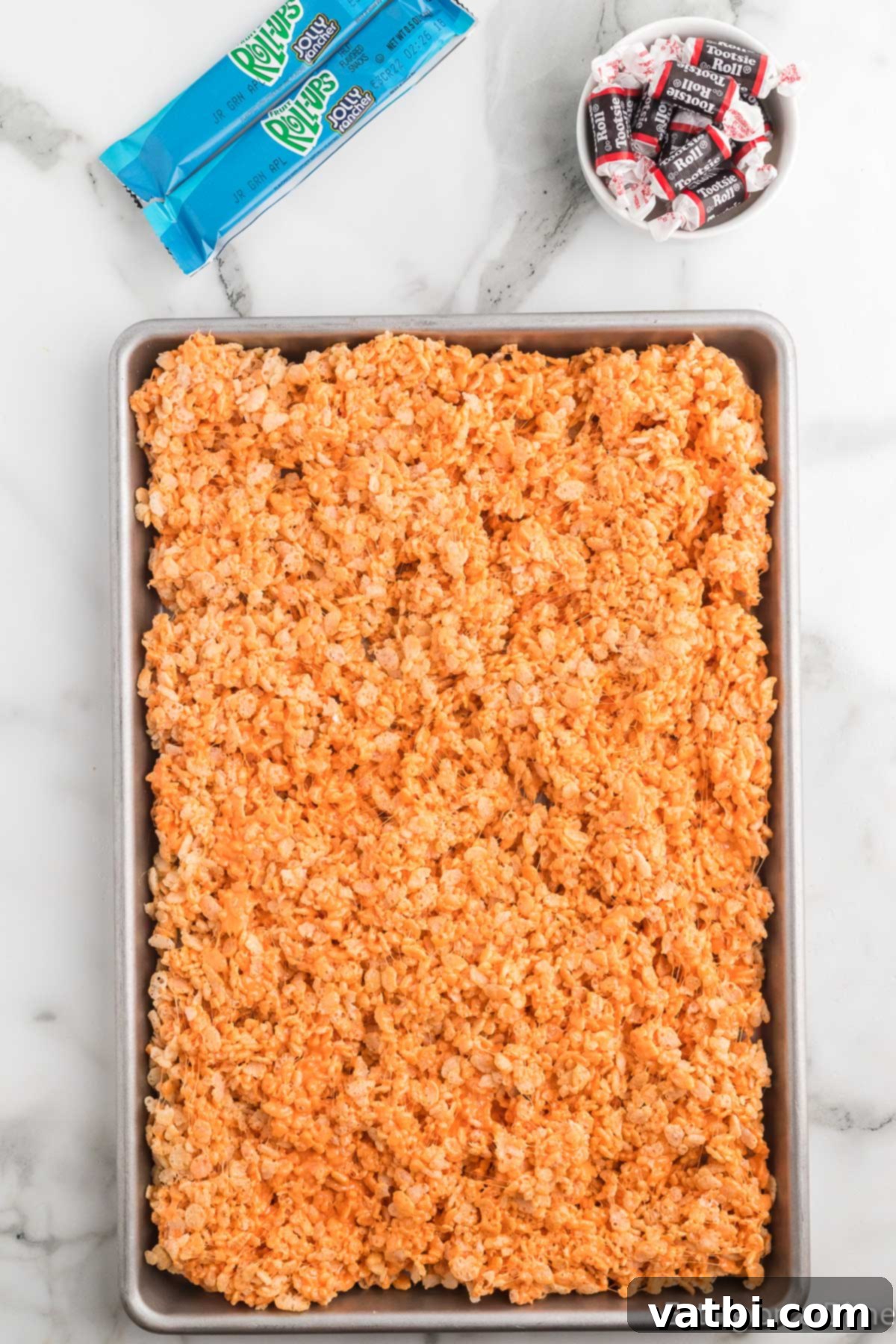 Autumn Rice Krispie Pumpkin Treats 11 Cereal mixture spread into baking dish.