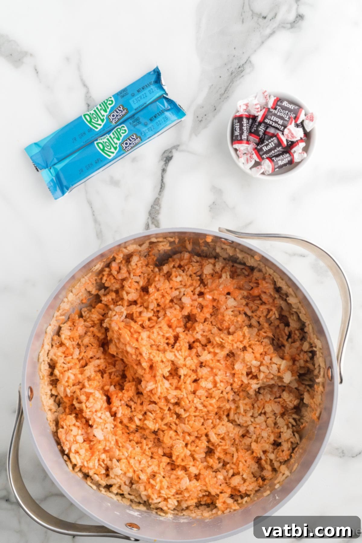 Autumn Rice Krispie Pumpkin Treats 10 Cereal and orange mixture combined in a pan.