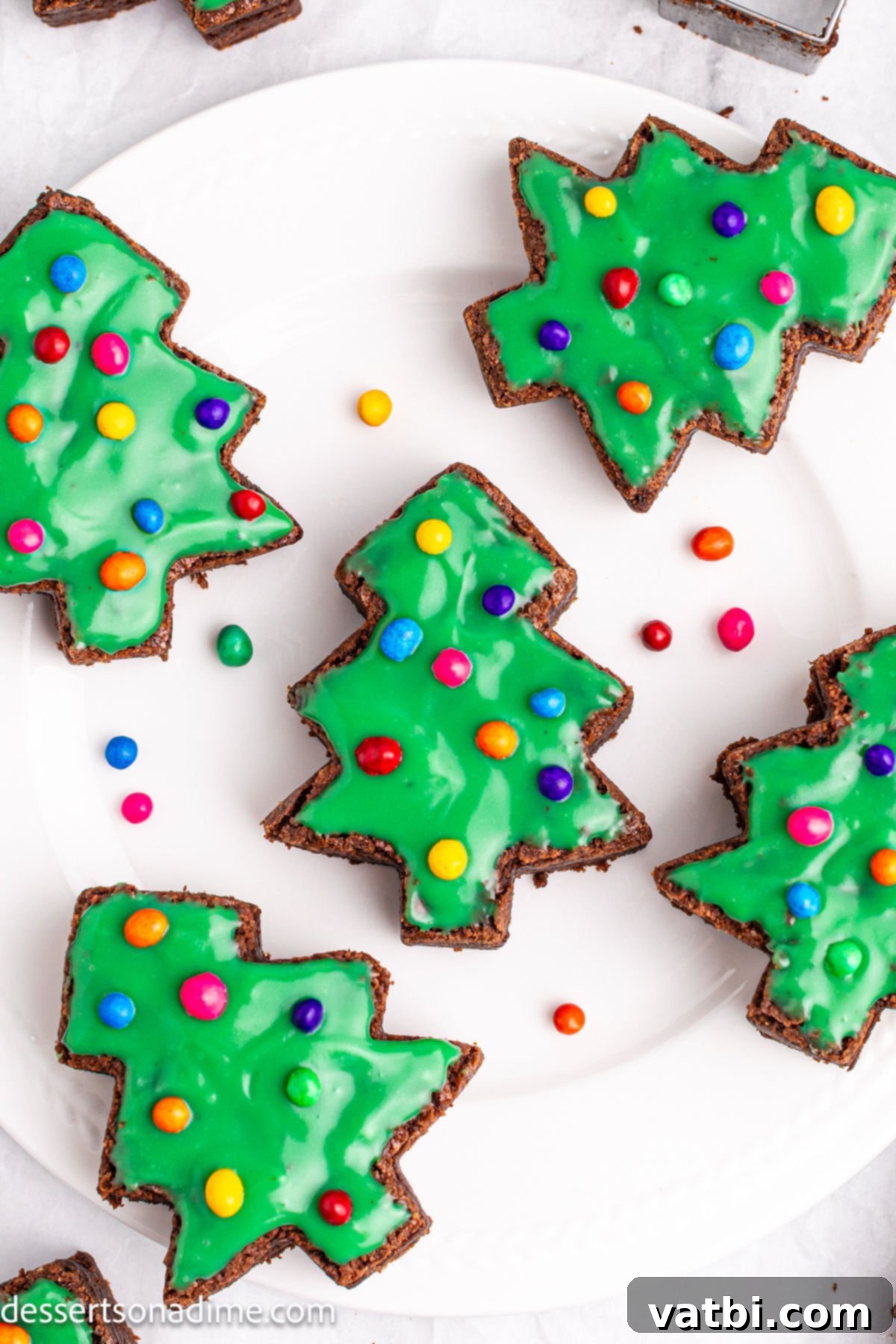Little Debbie Inspired Christmas Tree Brownies 2 Platter of homemade Little Debbie Christmas Tree Brownies with green frosting and festive sprinkles, ready to serve.
