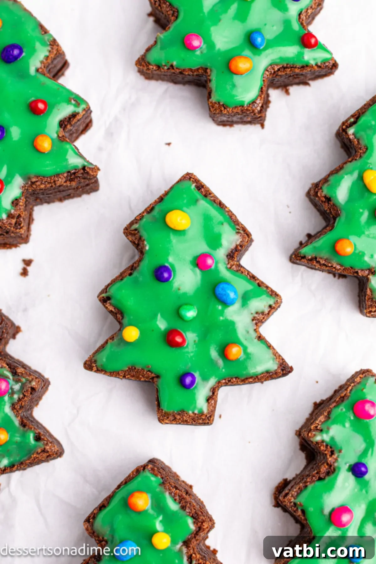 Little Debbie Inspired Christmas Tree Brownies 12 Multiple decorated Little Debbie Christmas Tree Brownies arranged neatly on wax paper, showcasing their perfect holiday appeal.