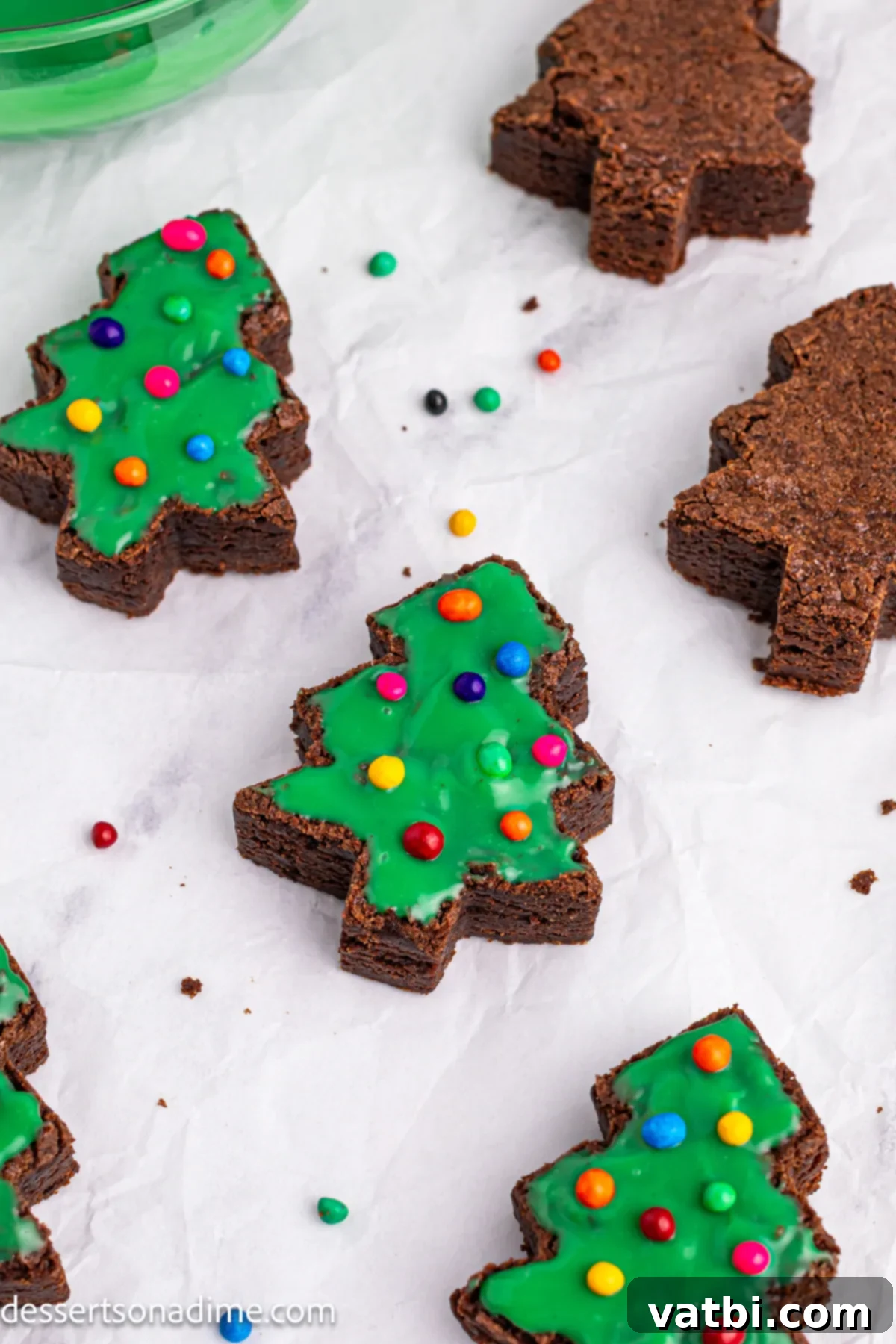 Little Debbie Inspired Christmas Tree Brownies 10 Mini candy-coated chocolate chips being sprinkled artistically onto the green-topped brownies for decoration.