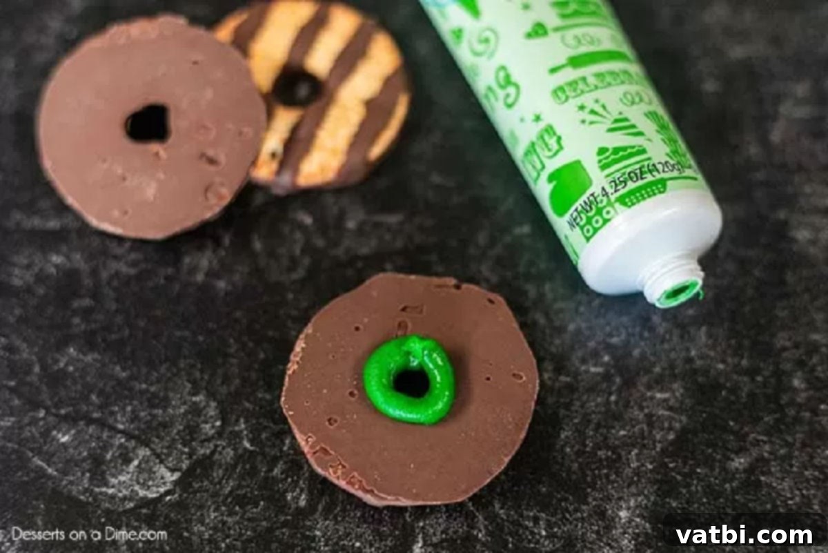 Bewitching Hat Bites 2 Fudge stripe cookies arranged with a dollop of green icing in the center of each chocolate side.
