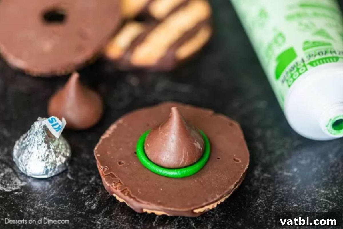 Bewitching Hat Bites 3 A Hershey's chocolate kiss gently pressed onto the green icing, forming the top of a witch hat.