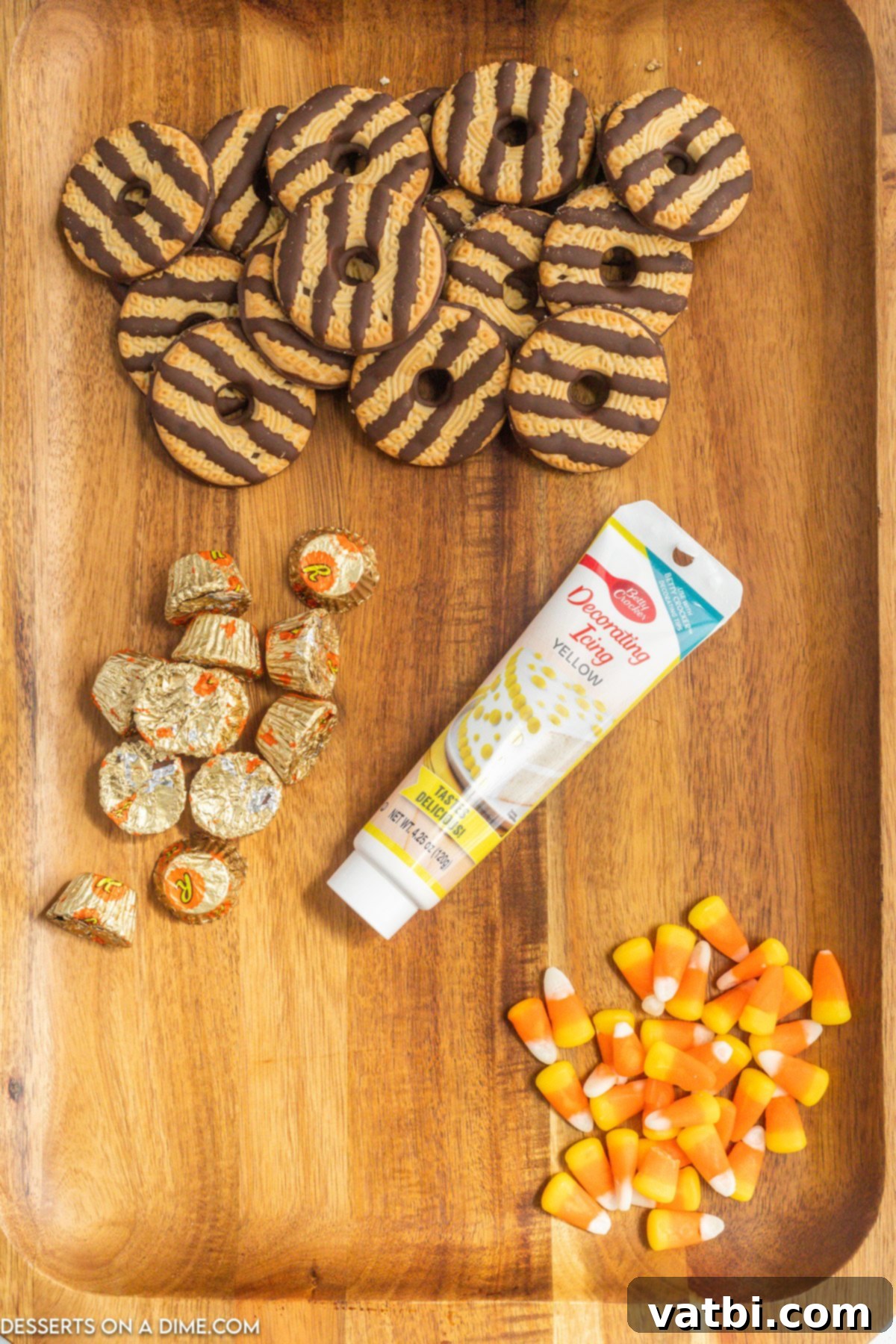 All four ingredients for Pilgrim Hat Cookies laid out on a table: Fudge Stripe Cookies, Reese's Peanut Butter Cups, Candy Corn, and Yellow Decorating Icing.