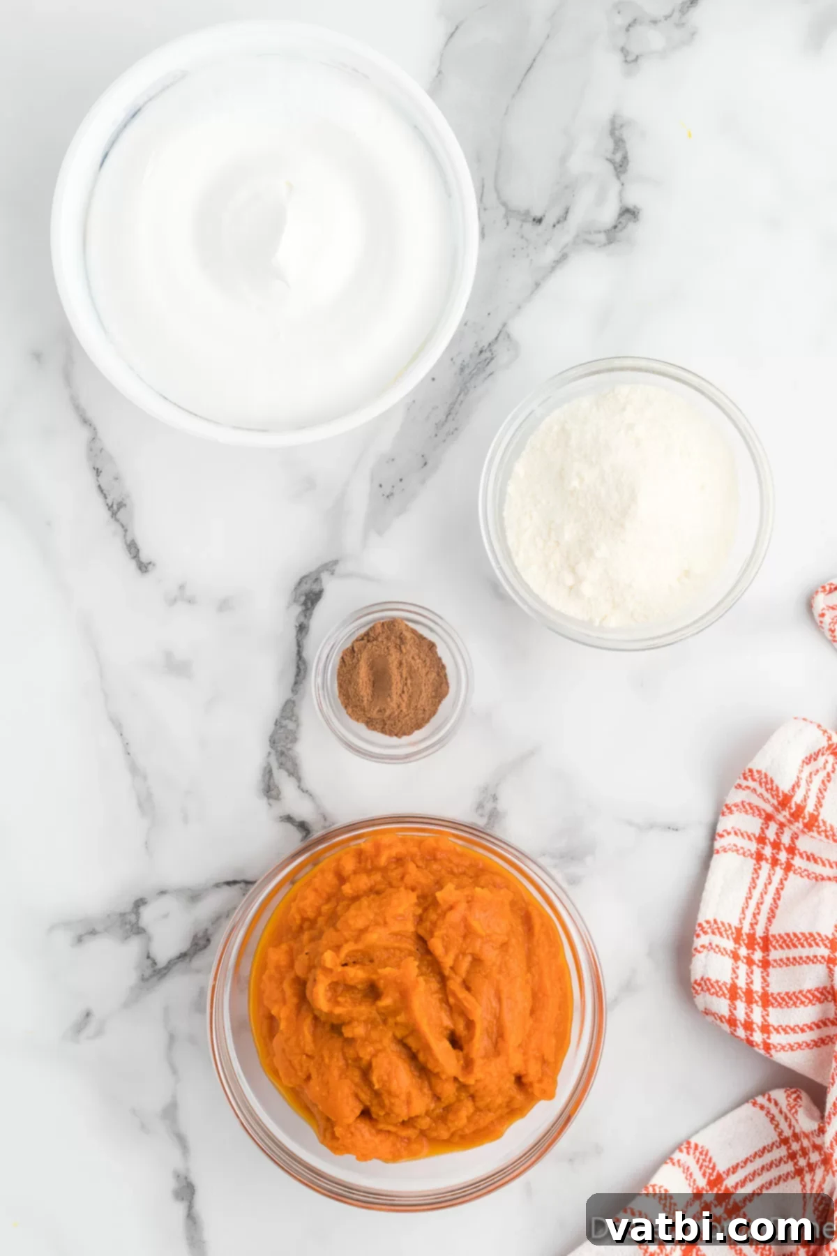Fluffy Pumpkin Dessert Dip 3 Ingredients for pumpkin dip including canned pumpkin puree, instant vanilla pudding mix, pumpkin pie spice, and thawed whipped topping in individual bowls.