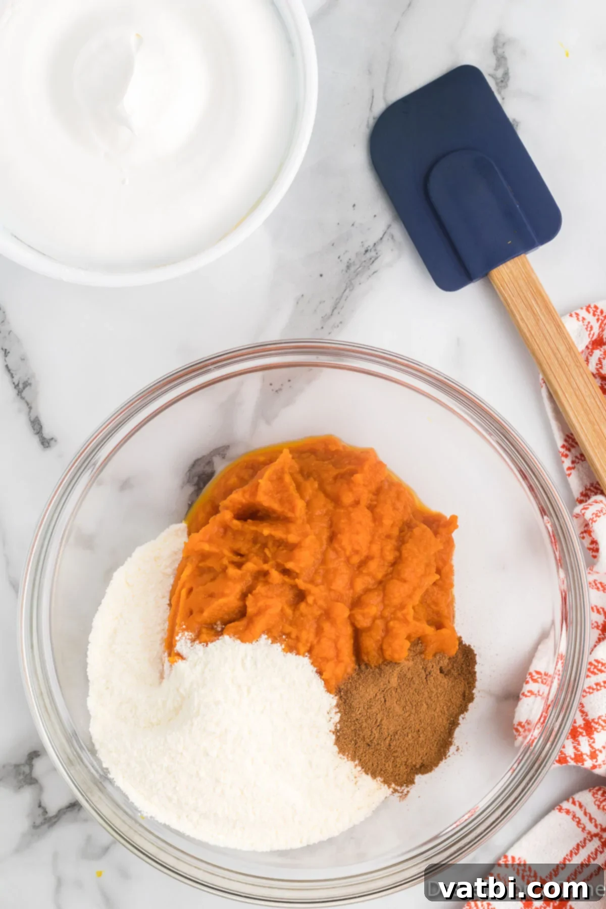 Fluffy Pumpkin Dessert Dip 4 Canned pumpkin puree and vanilla pudding mix ready to be combined in a mixing bowl.