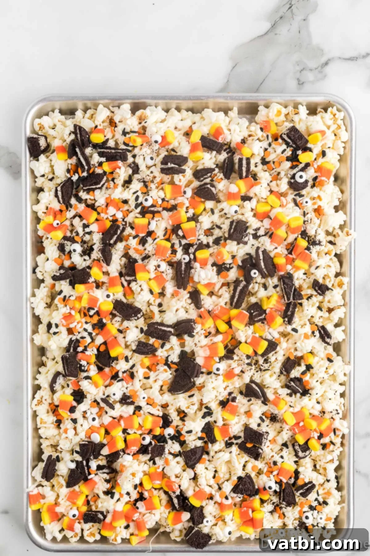 Fright Night Popcorn 7 Topping the popcorn with crushed Oreo cookies, candy corn, and candy eyes.