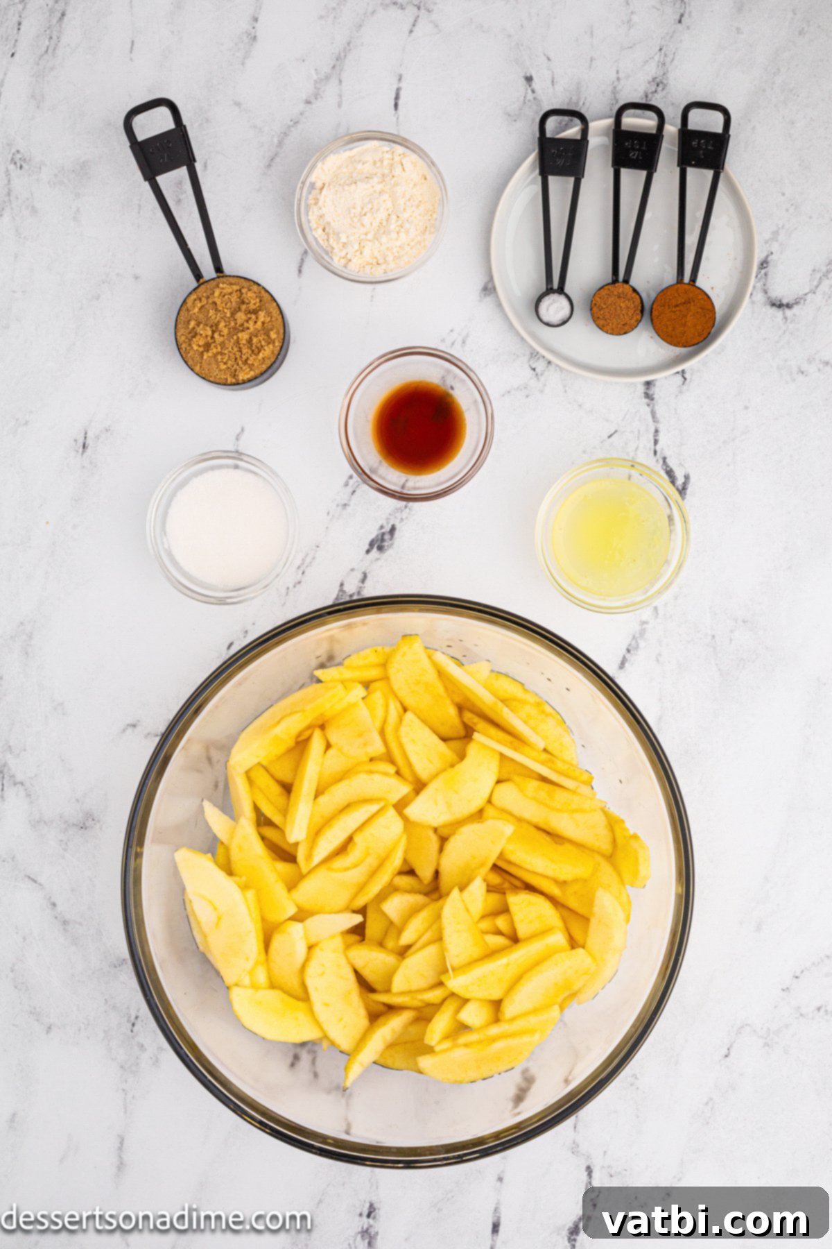Golden Apple Cobbler Perfection 3 Selection of ingredients for homemade apple cobbler including sliced apples, brown sugar, granulated sugar, flour, lemon, cinnamon, and nutmeg.