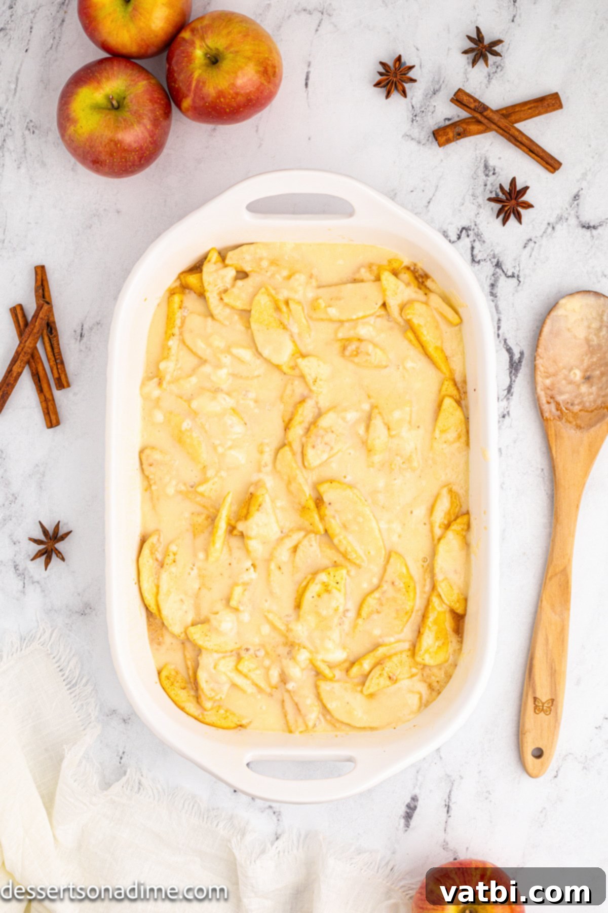 Golden Apple Cobbler Perfection 8 The smooth, thick cobbler topping batter poured evenly over the spiced apple filling in the baking dish, ready for baking.