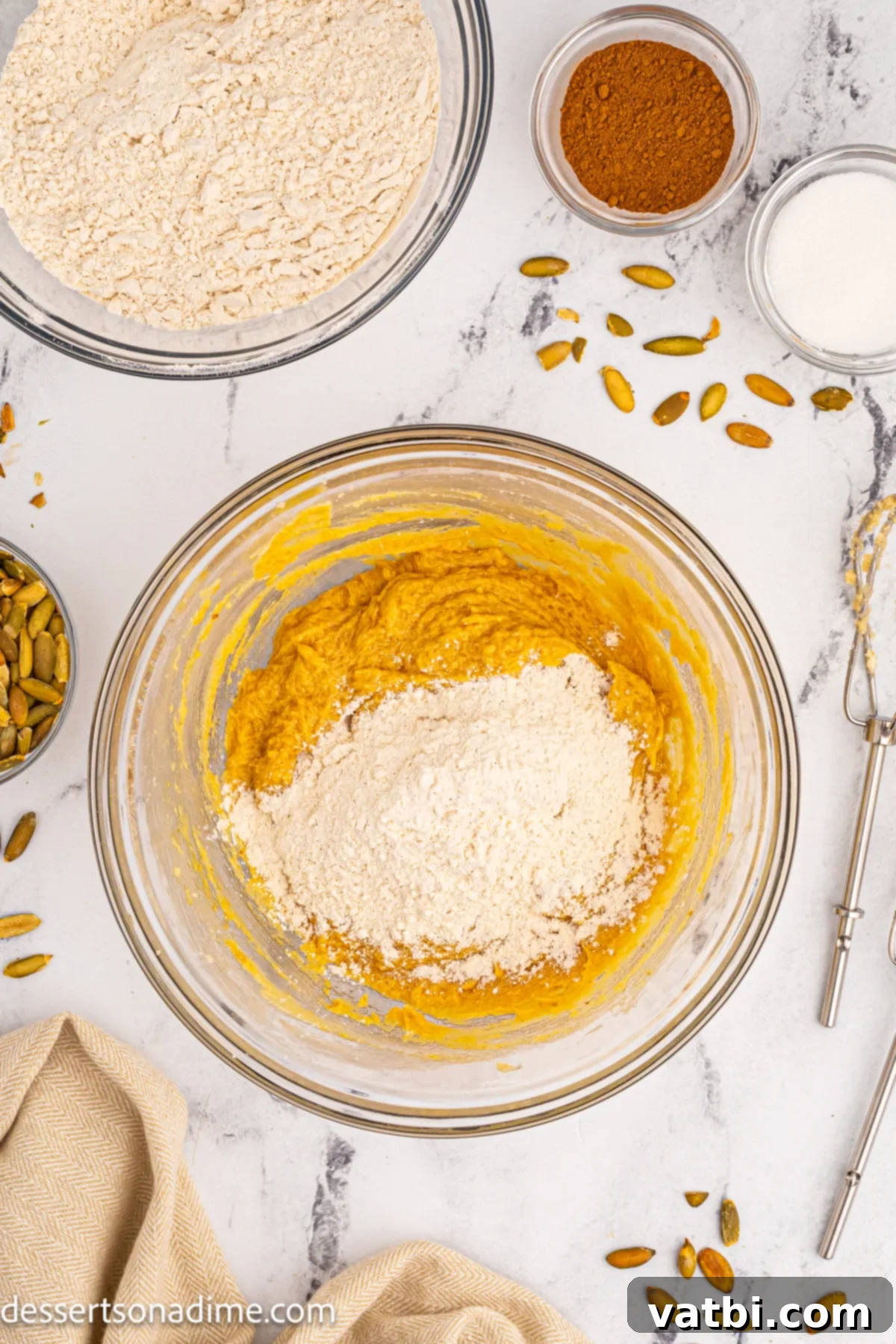 Autumn Spice Pumpkin Snickerdoodles 6 Dry ingredients like flour, baking soda, cream of tartar, salt, and pumpkin pie spice mixed in a separate bowl.