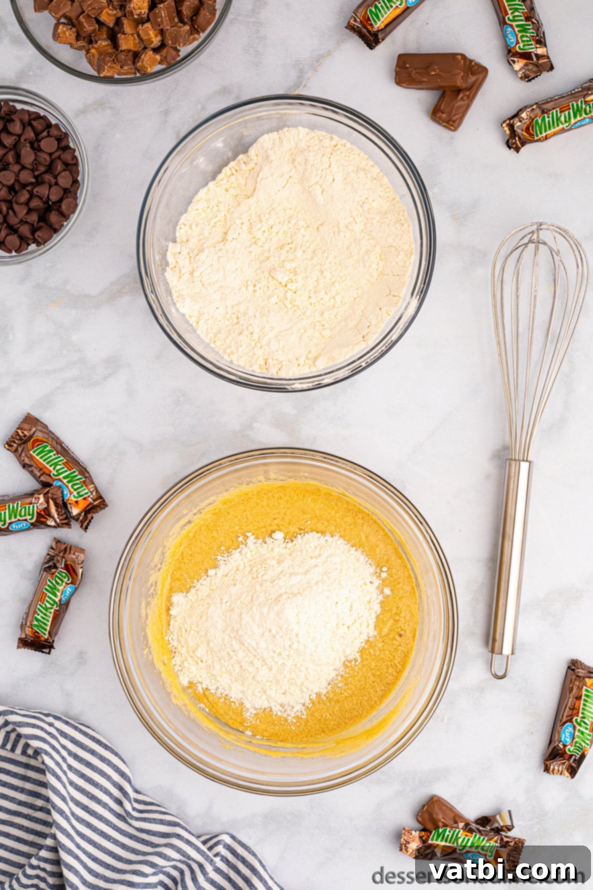 Dry flour mixture being gradually added to the wet butter and sugar mixture in a large bowl.