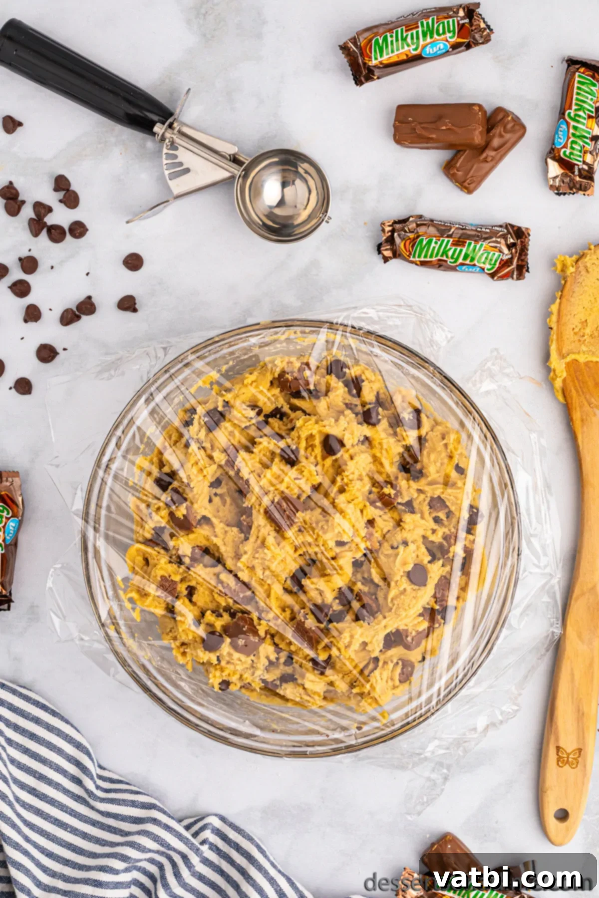 Bowl of cookie dough with chocolate chips folded in, ready for refrigeration.