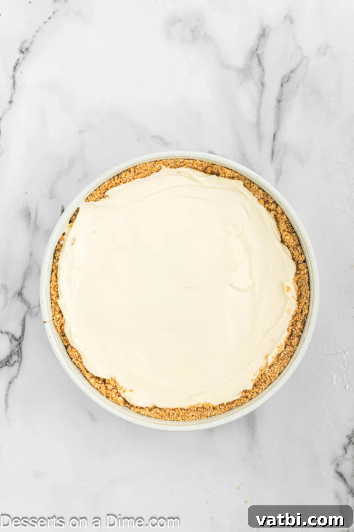Effortless No-Bake Cheesecake 8 Smooth cheesecake filling poured into the chilled graham cracker crust in a springform pan.