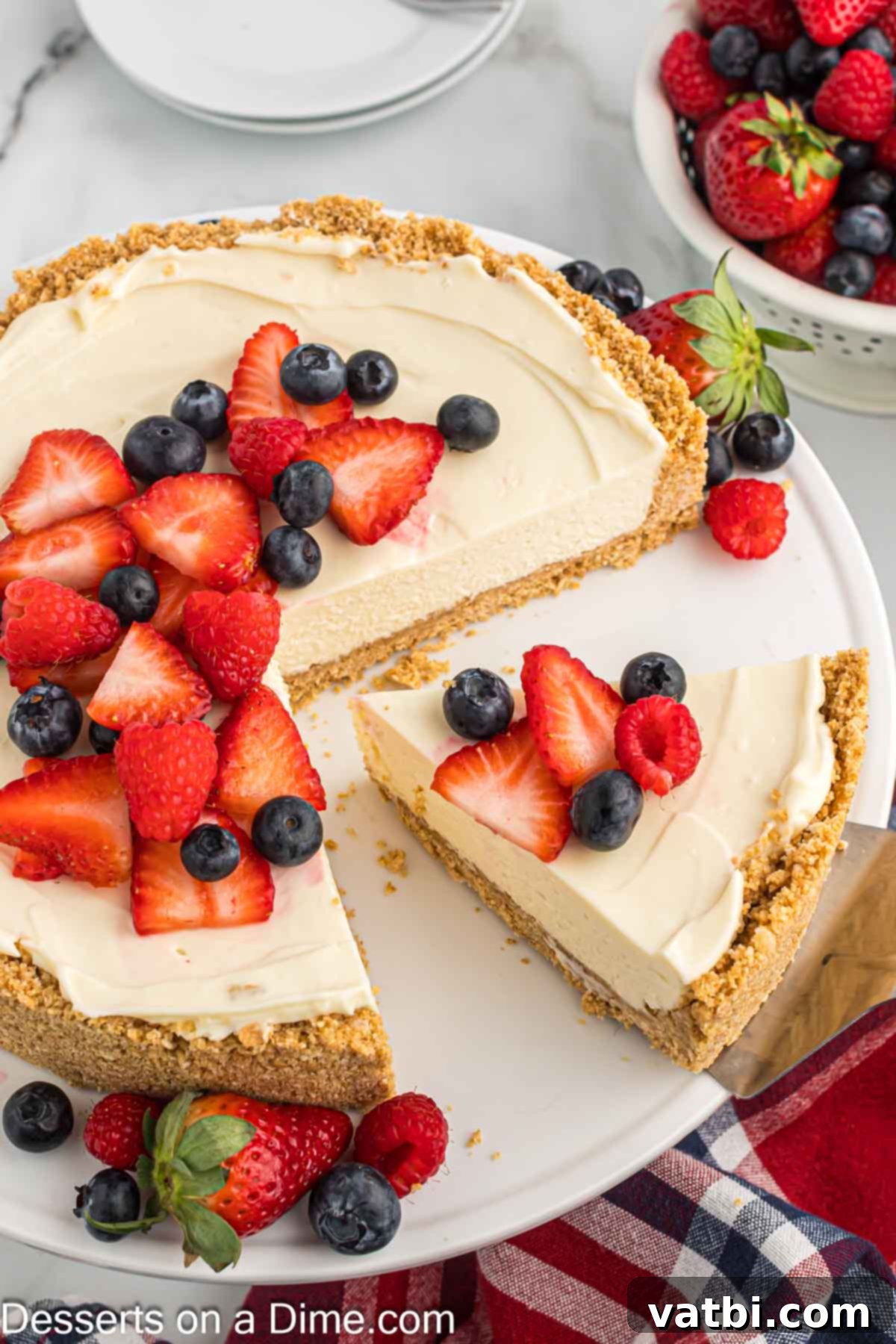 Effortless No-Bake Cheesecake 9 A chilled no bake cheesecake, garnished with fresh fruit, being sliced for serving.