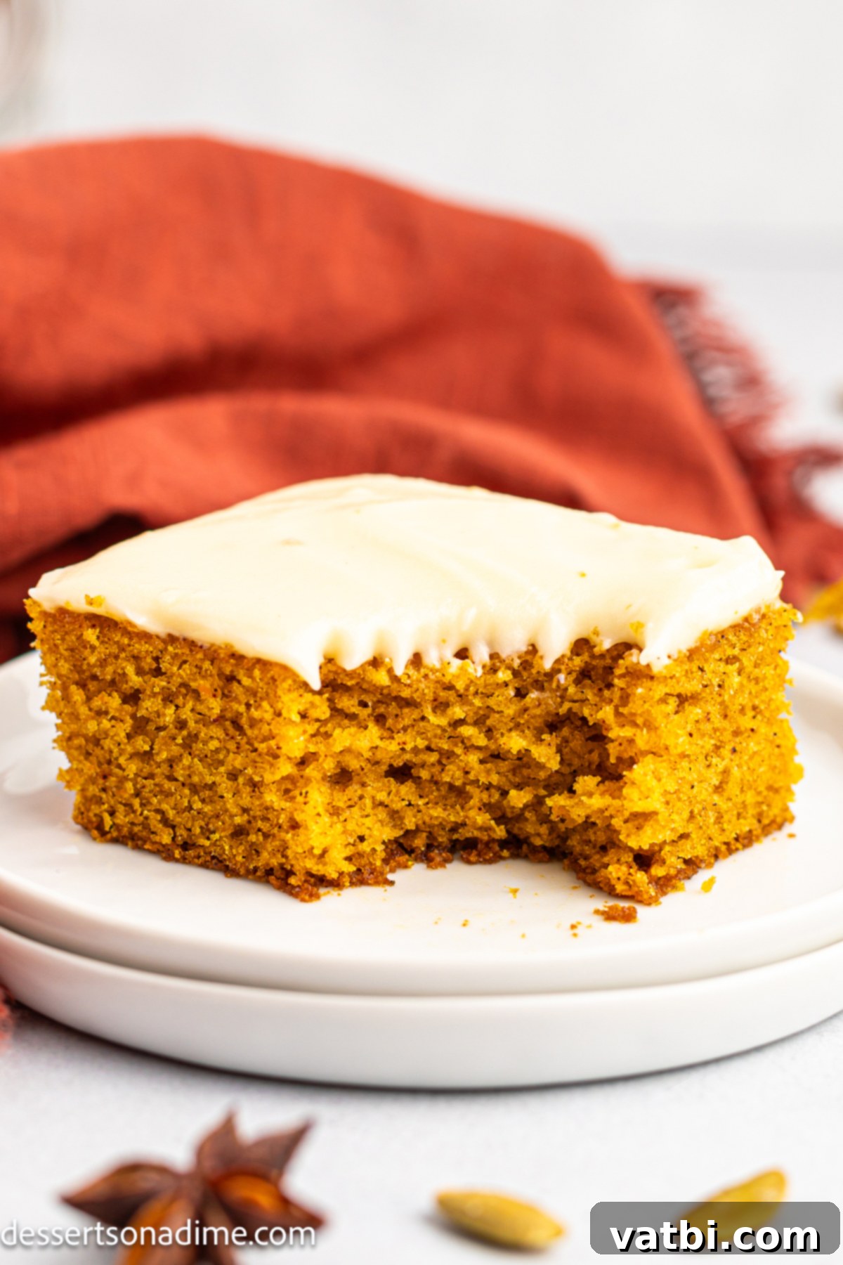 Harvest Pumpkin Sheet Cake 2 Pumpkin cake sliced on a plate, showing the moist cake and thick cream cheese frosting.