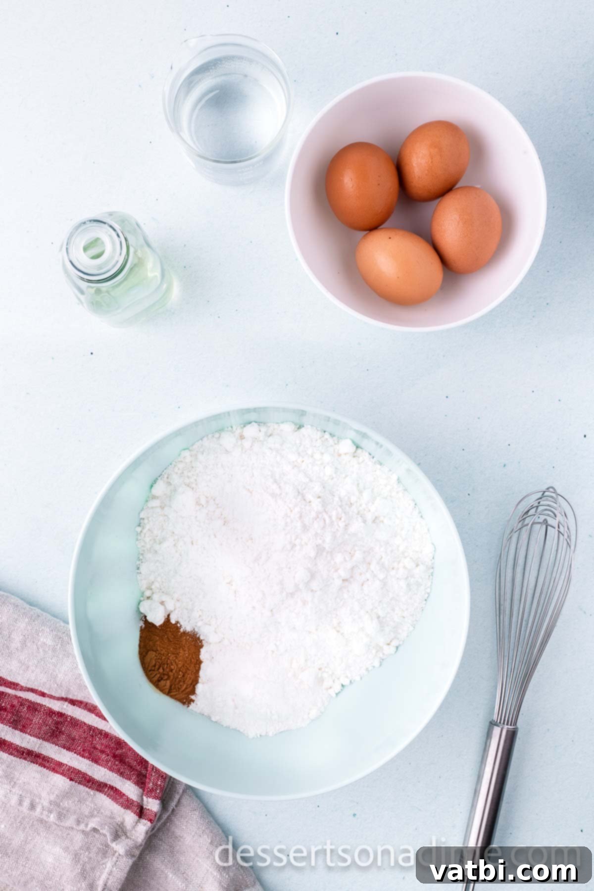 Mixing together white cake mix, instant vanilla pudding mix, and ground cinnamon in a large bowl with a whisk.