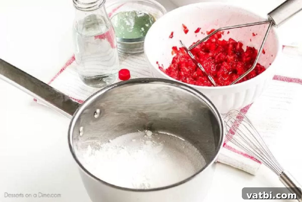 Sweet Strawberry Sauce Recipe 3 A saucepan on the stove containing a mixture of white sugar and cornstarch, ready for liquid ingredients.