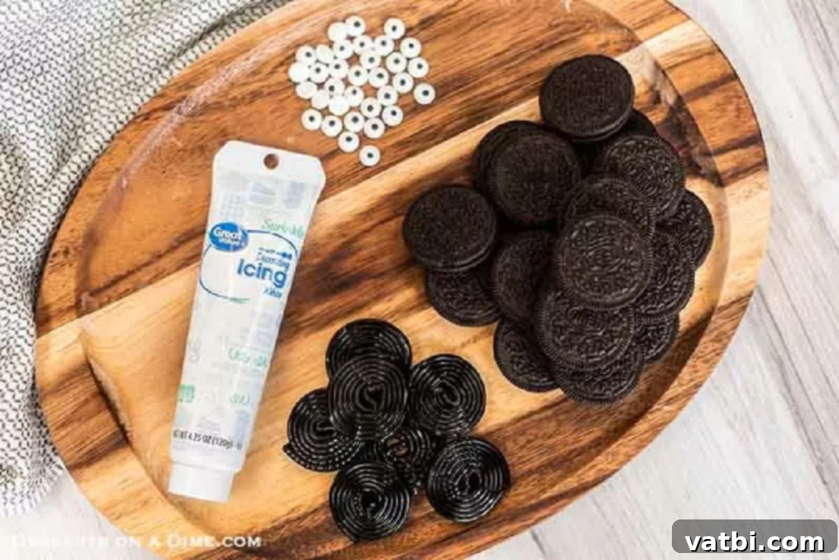 Enjoy Spider Oreo Cookies for a fun and festive no bake Halloween snack. Kids will love these oreo spider cookies and they are super easy to make for treats. Spider Oreos are quick and easy. #dessertonadime #spideroreocookies #halloweencookies #halloweenfoods A simple array of ingredients for making Oreo Spiders: Oreo cookies, a roll of black licorice, colorful candy eyes, and a tube of white icing.