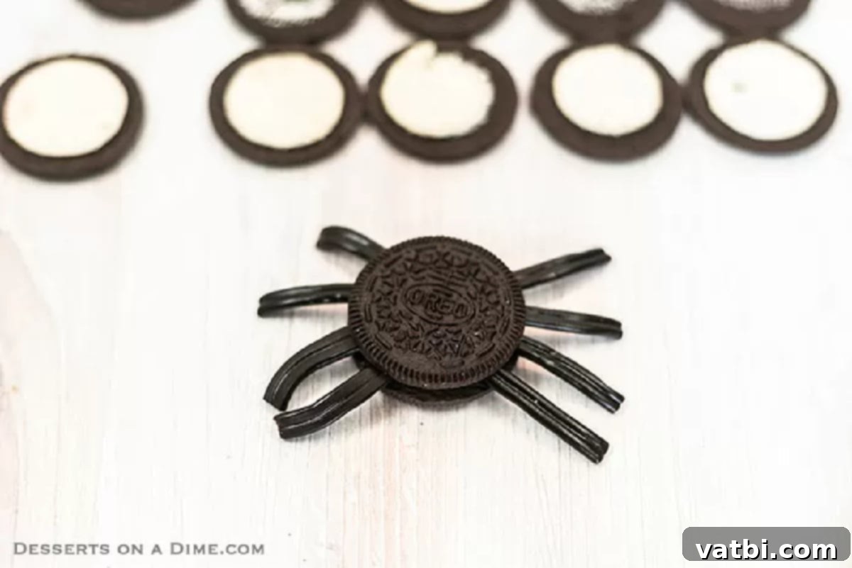Spooky Oreo Spider Cookies 4 The top plain Oreo cookie wafer is gently placed back onto the cream-filled half with the licorice legs, creating the spider's body.