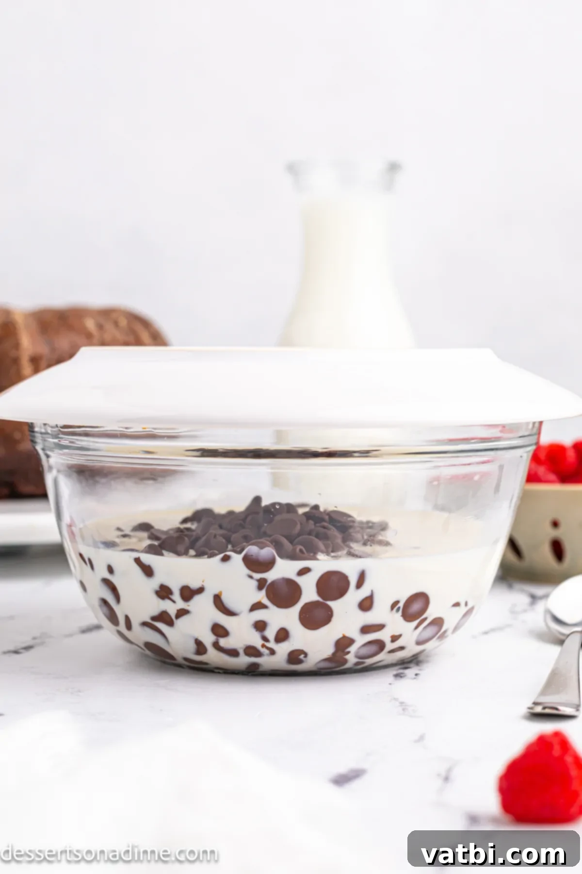 Decadent Chocolate Brownie Cake 4 Mixing bowl with chocolate chips and heavy cream.