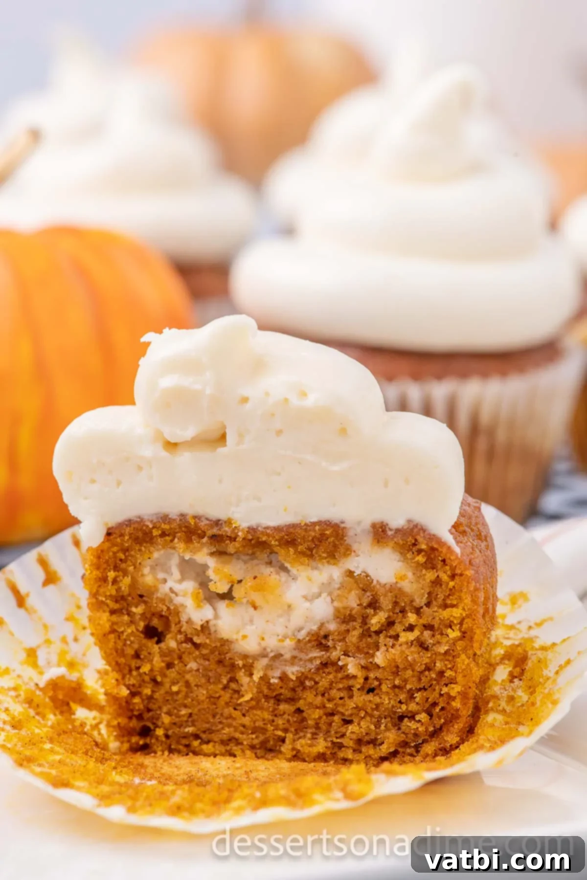 Finished Pumpkin Cheesecake Cupcakes, each beautifully topped with a swirl of creamy cream cheese frosting.