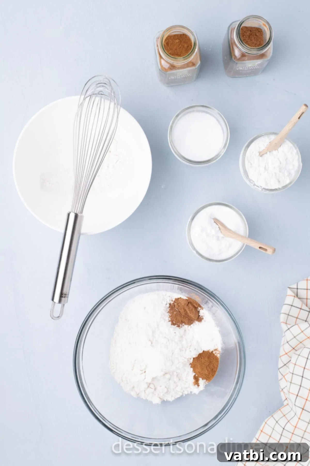 Dry ingredients like flour, pumpkin pie spice, baking powder, cinnamon, and salt, perfectly combined in a mixing bowl.