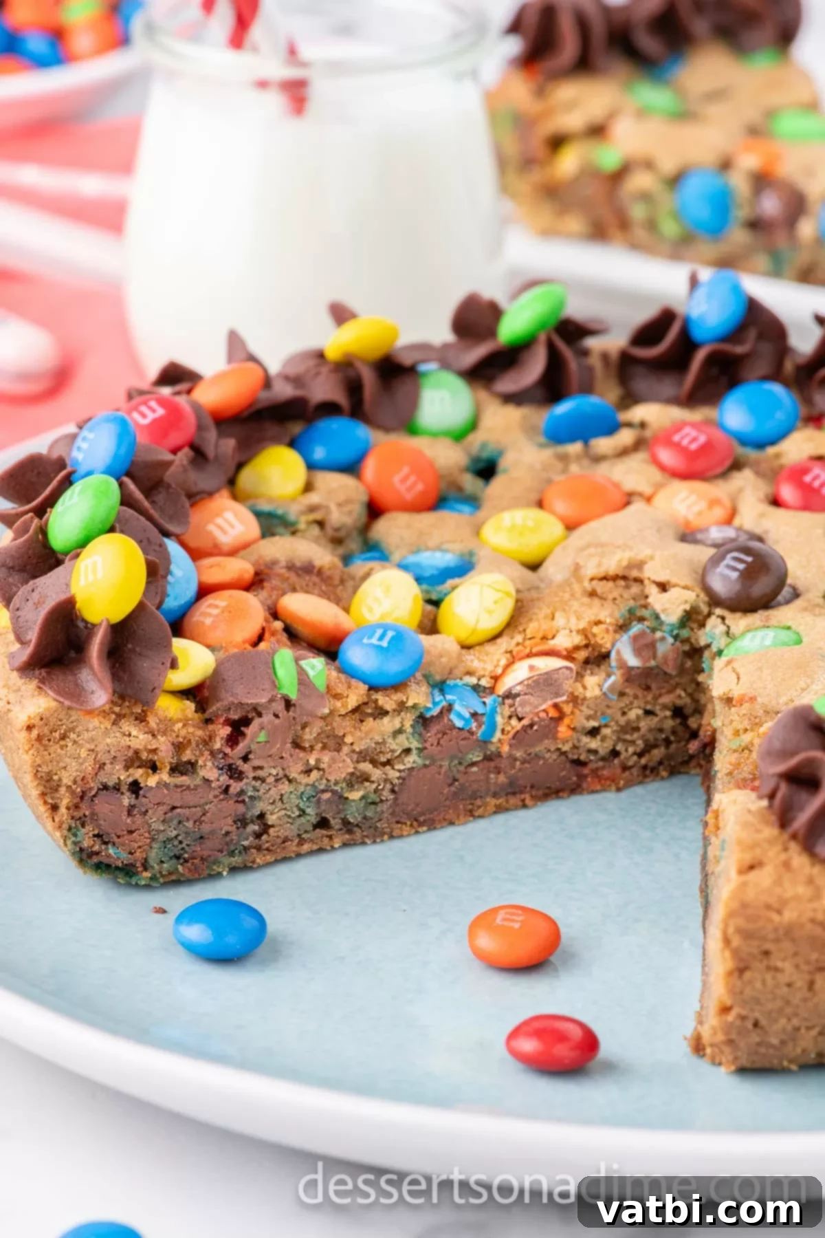 M&M cookie cake sliced on a platter. 