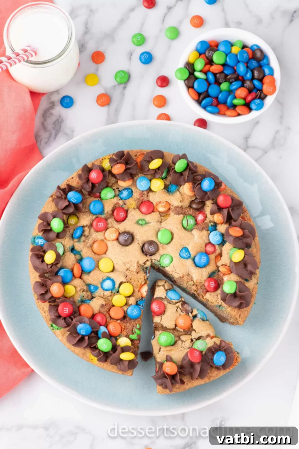 M&M cookie cake sliced on a platter. 
