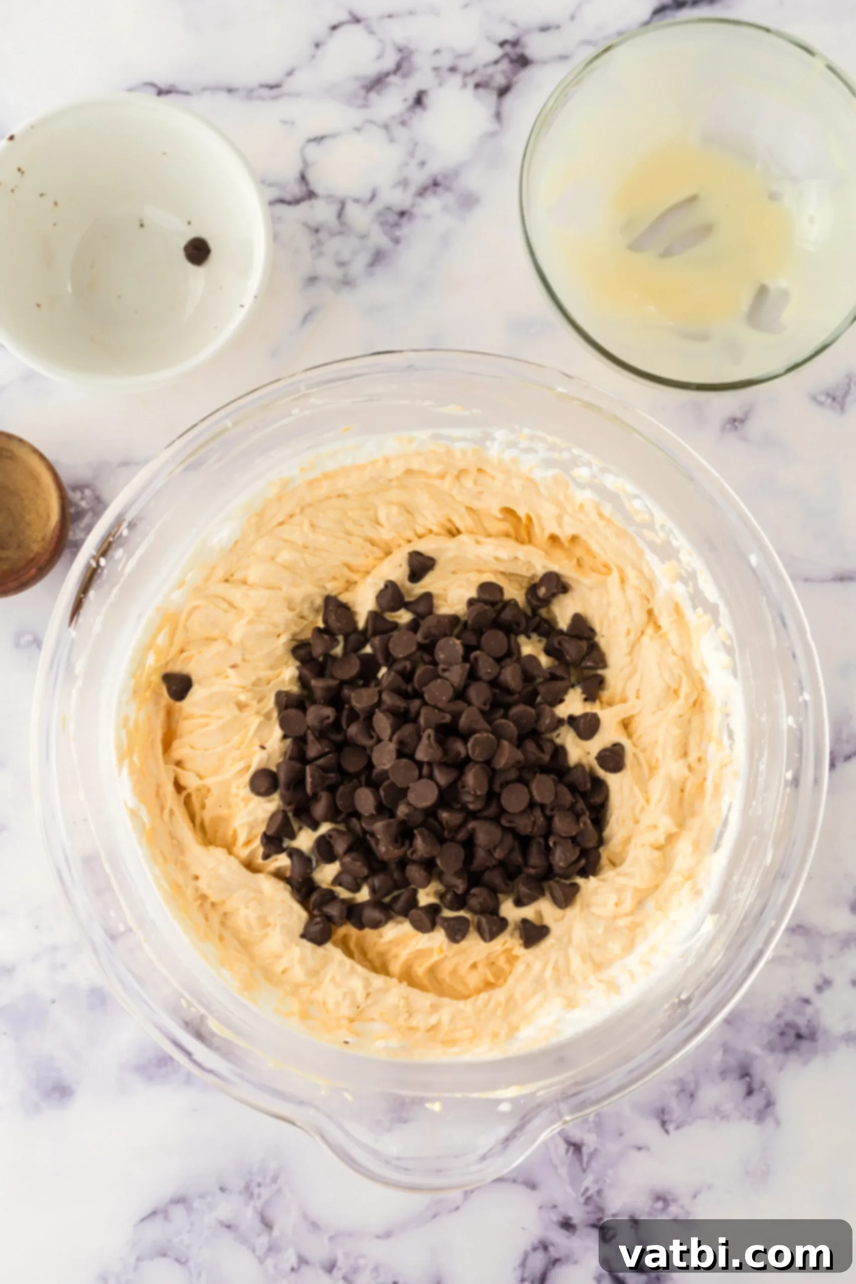 Spiced Pumpkin Chocolate Chunk Dream 6 Semi-sweet chocolate chips being folded into the pumpkin ice cream mixture with a spatula