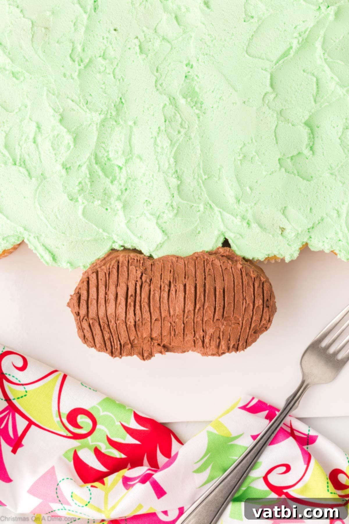Brown frosting spread on the two base cupcakes, with fork tines used to create a wood-grain texture for the tree trunk.