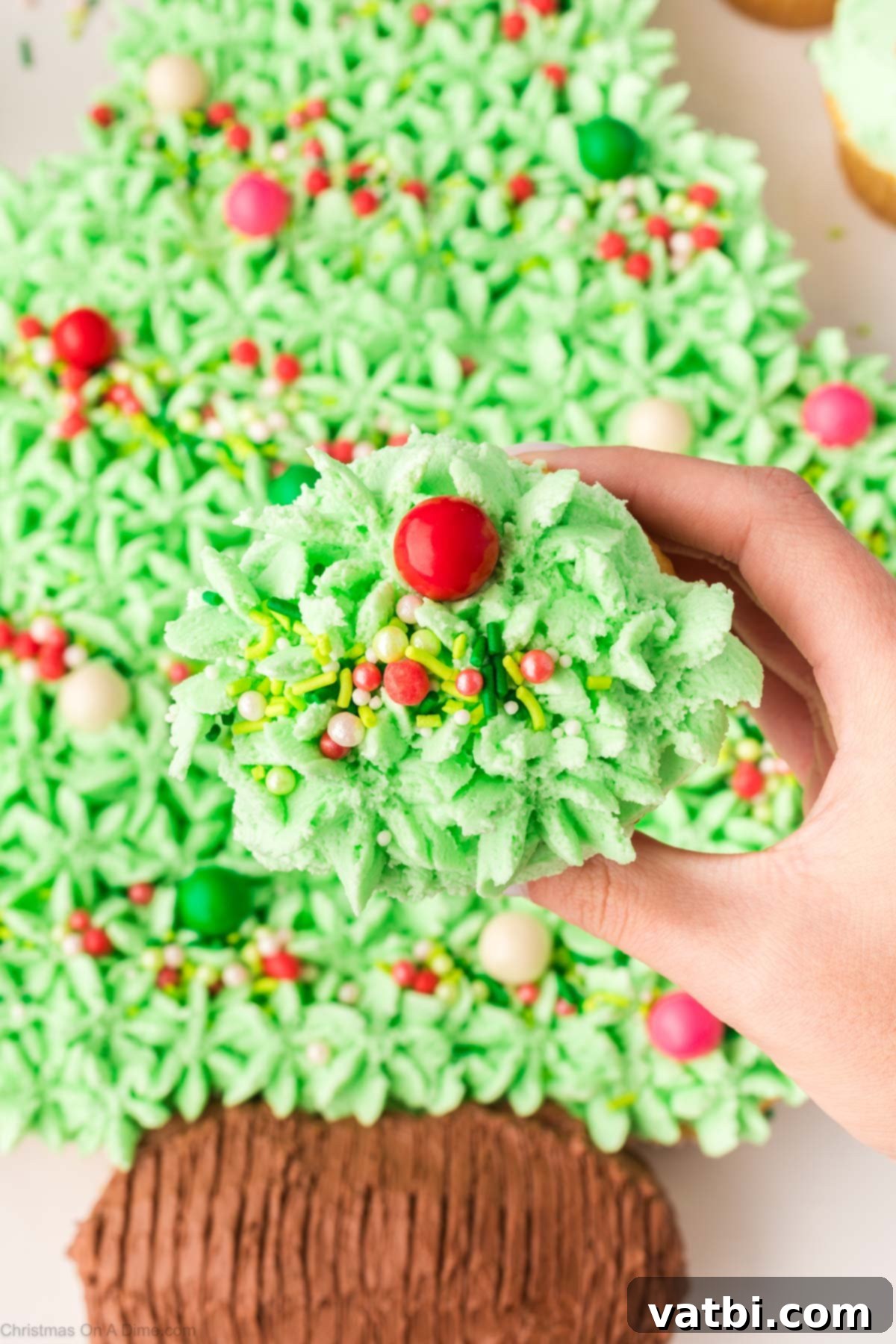 A guest pulling apart a cupcake from the Christmas Tree Cupcake Cake, showing the individual servings.