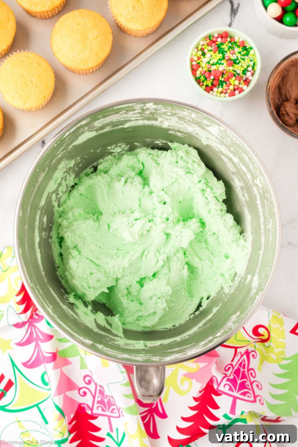 Green gel food coloring being mixed into the remaining white frosting to create a vibrant green hue.