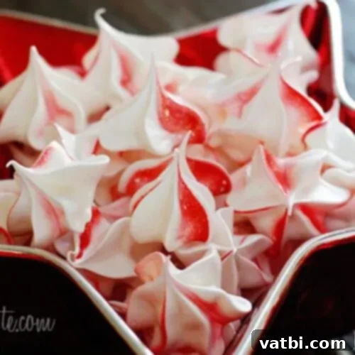 Festive Candy Treats 34 Peppermint Meringues, light and airy cookies with peppermint swirls, perfect for Christmas.