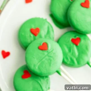 Festive Candy Treats 8 Grinch Oreo Pops, a perfect holiday dessert with classic Oreos dipped in green candy and topped with a red heart.