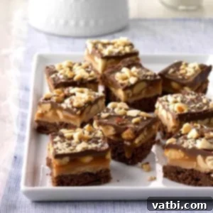Marshmallow Fluff Delights 11 Peanut Caramel Brownie Bites with multiple decadent layers, cut into small squares.