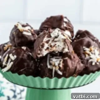 Marshmallow Fluff Delights 12 Chocolate-dipped Coconut Truffles with sprinkles, showcasing their soft, creamy center.