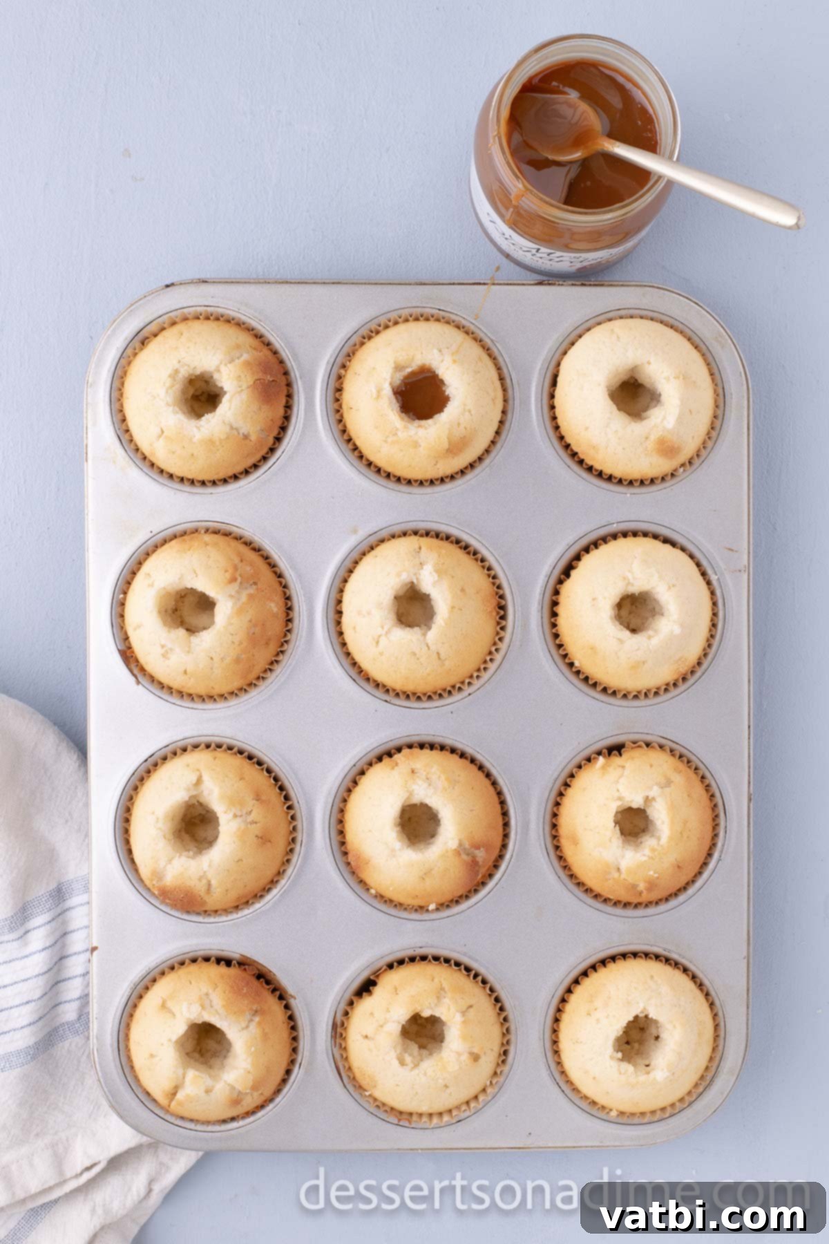 Decadent Salted Caramel Cupcakes 11 The center of a baked cupcake being cored out with a small knife.