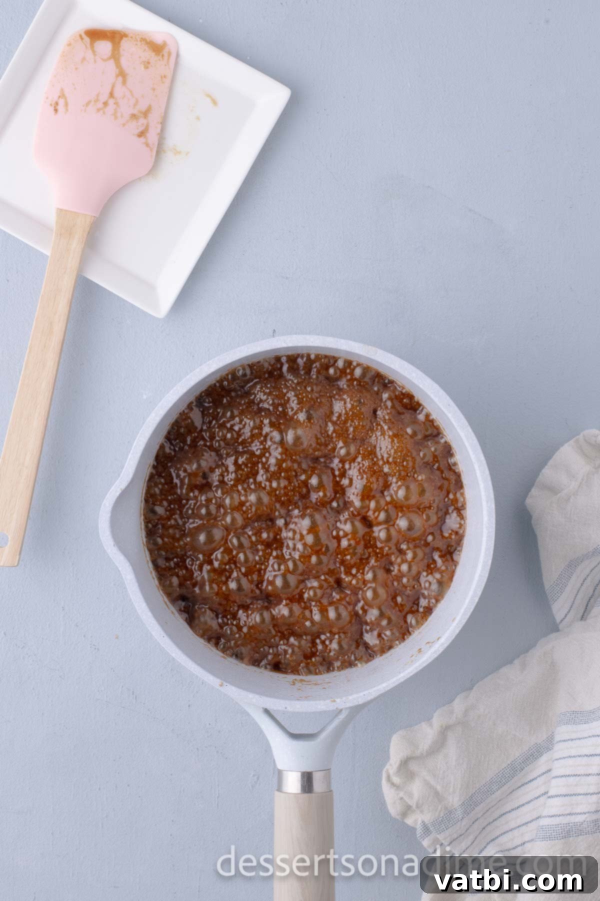 Decadent Salted Caramel Cupcakes 14 Caramel frosting mixture bubbling and turning amber in a saucepan.