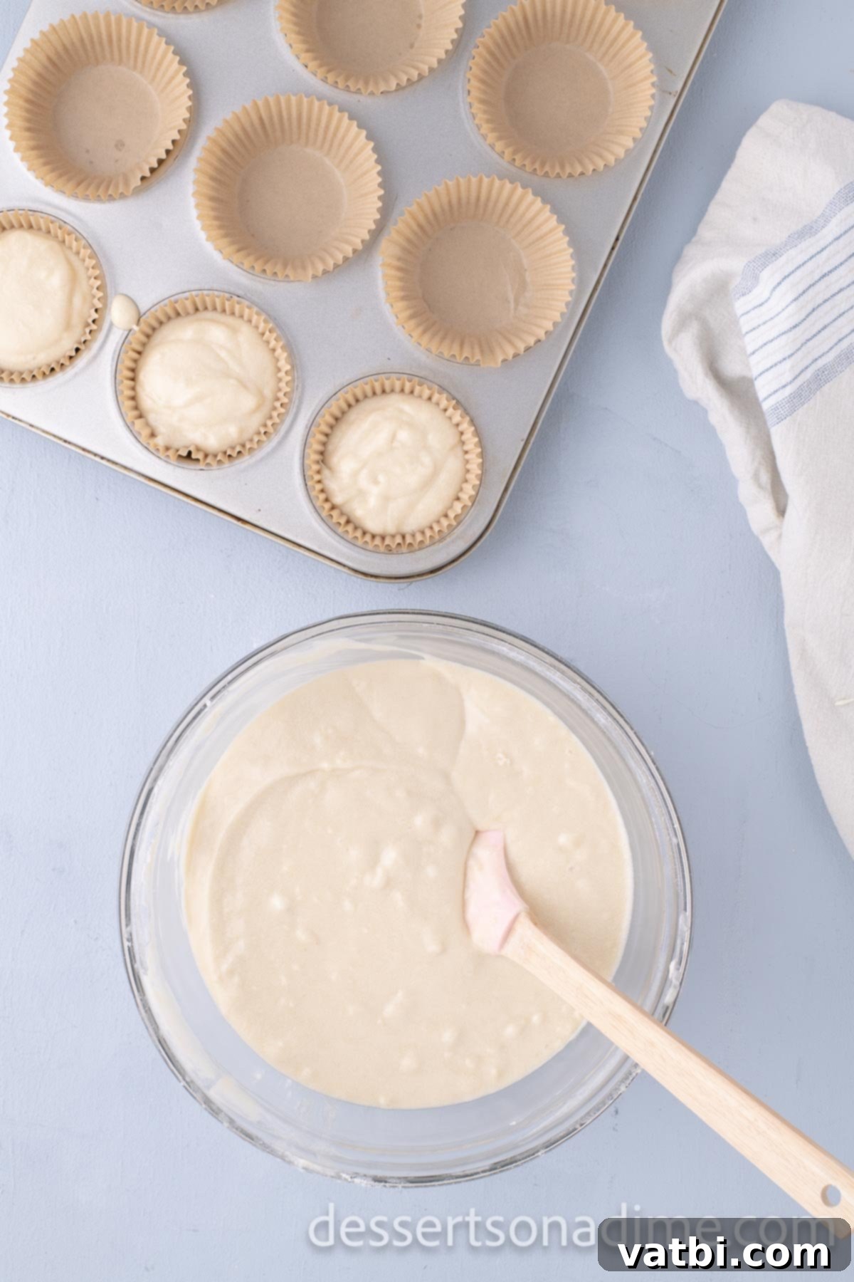 Decadent Salted Caramel Cupcakes 9 Cupcake batter being spooned into lined muffin pans.