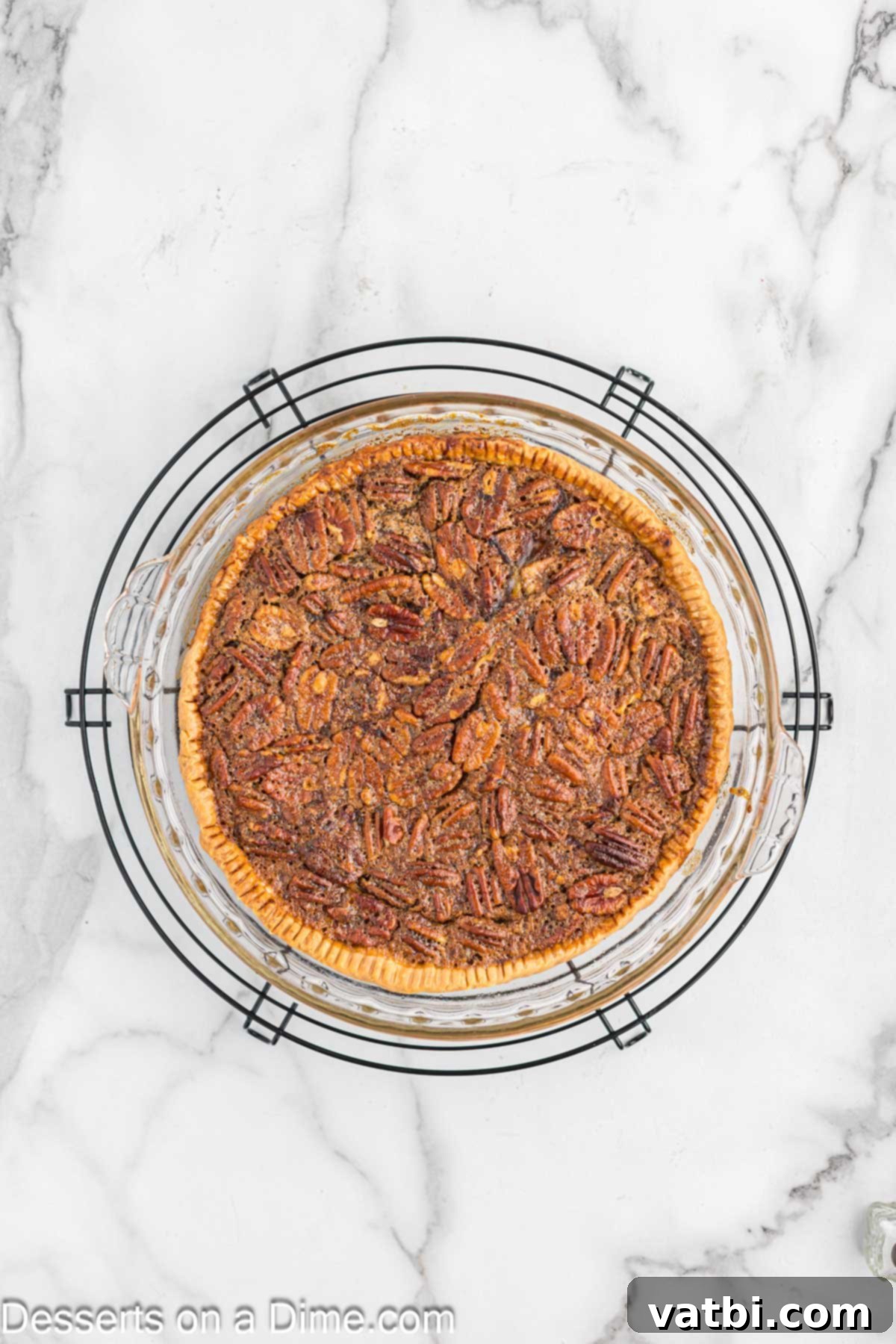 Paula Deen's Southern Pecan Delight 6 A freshly baked Paula Deen Pecan Pie, golden brown and glistening, is cooling on a wire rack.