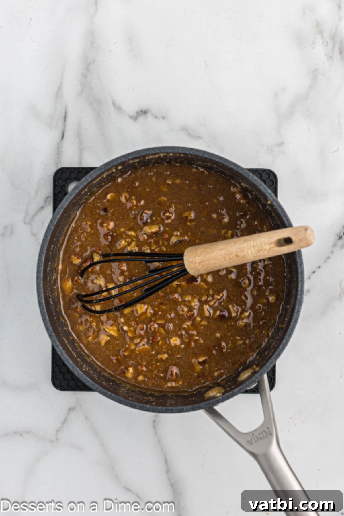 Paula Deen's Southern Pecan Delight 7 A rich, thick pecan caramel mixture is combined in a saucepan, bubbling gently as it cooks.