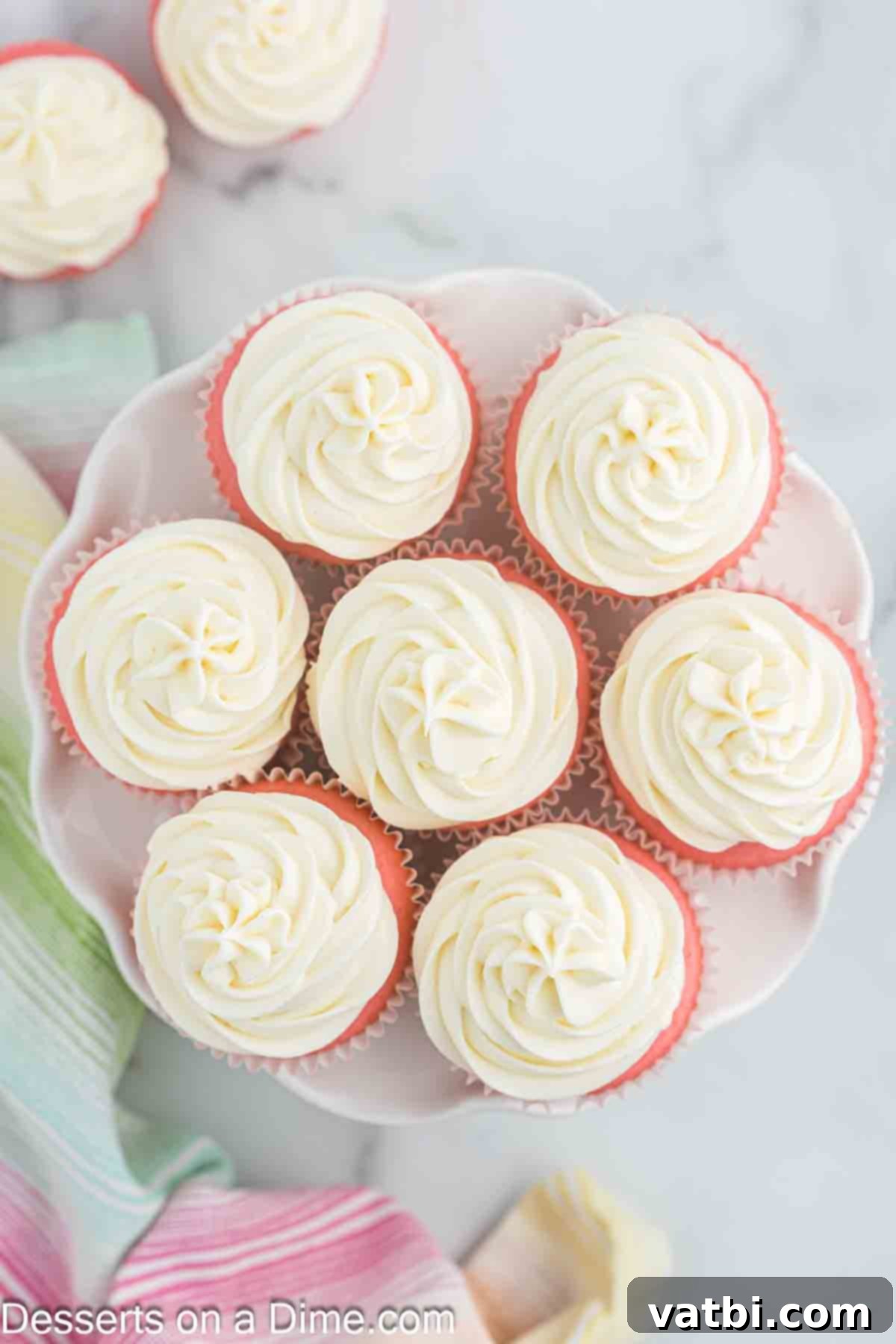Blushing Velvet Cupcakes 13 A platter brimming with beautifully frosted pink velvet cupcakes, ready for guests to enjoy.