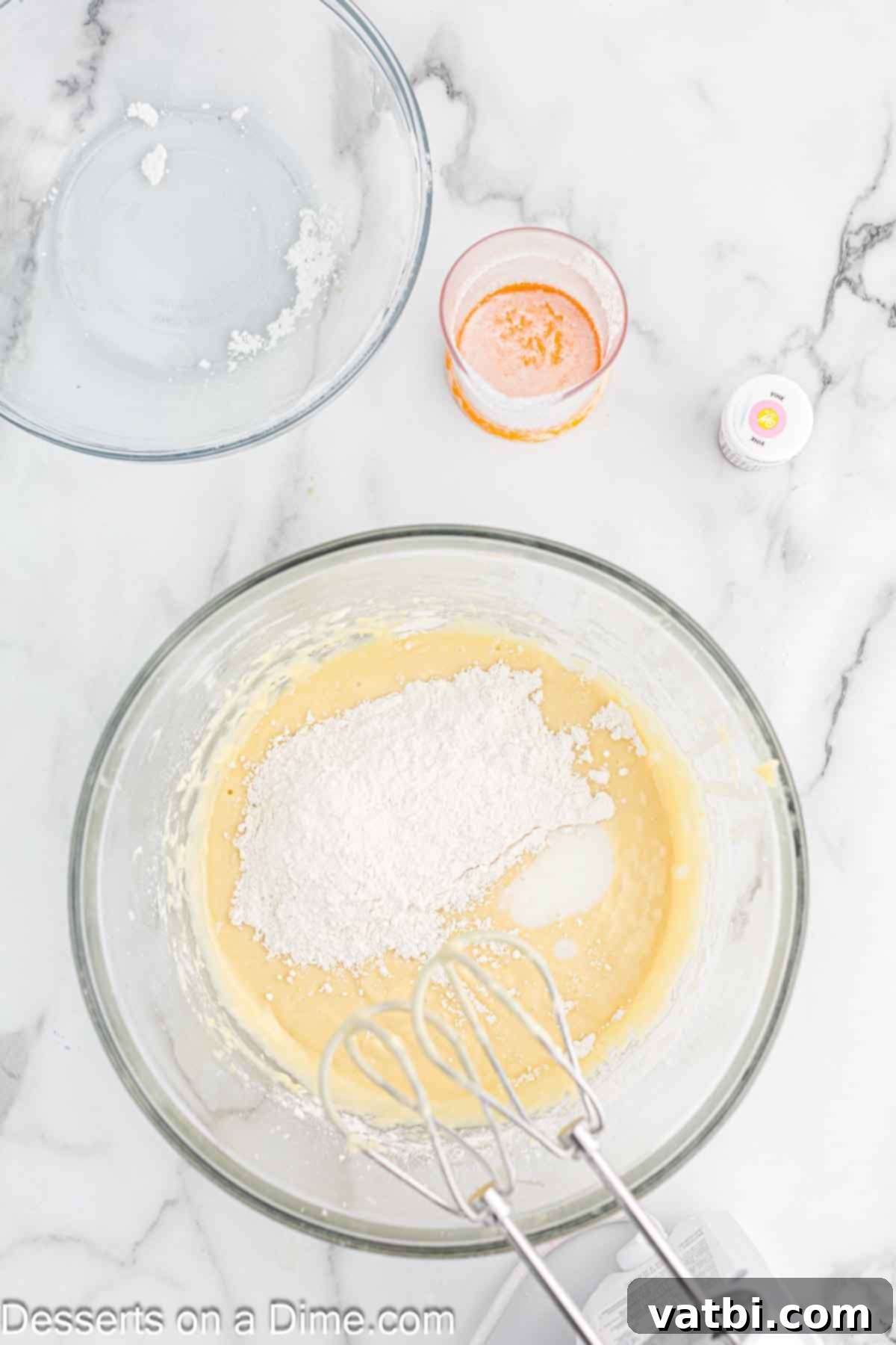 Blushing Velvet Cupcakes 6 Dry ingredients slowly added to the wet mixture in a bowl and combined.