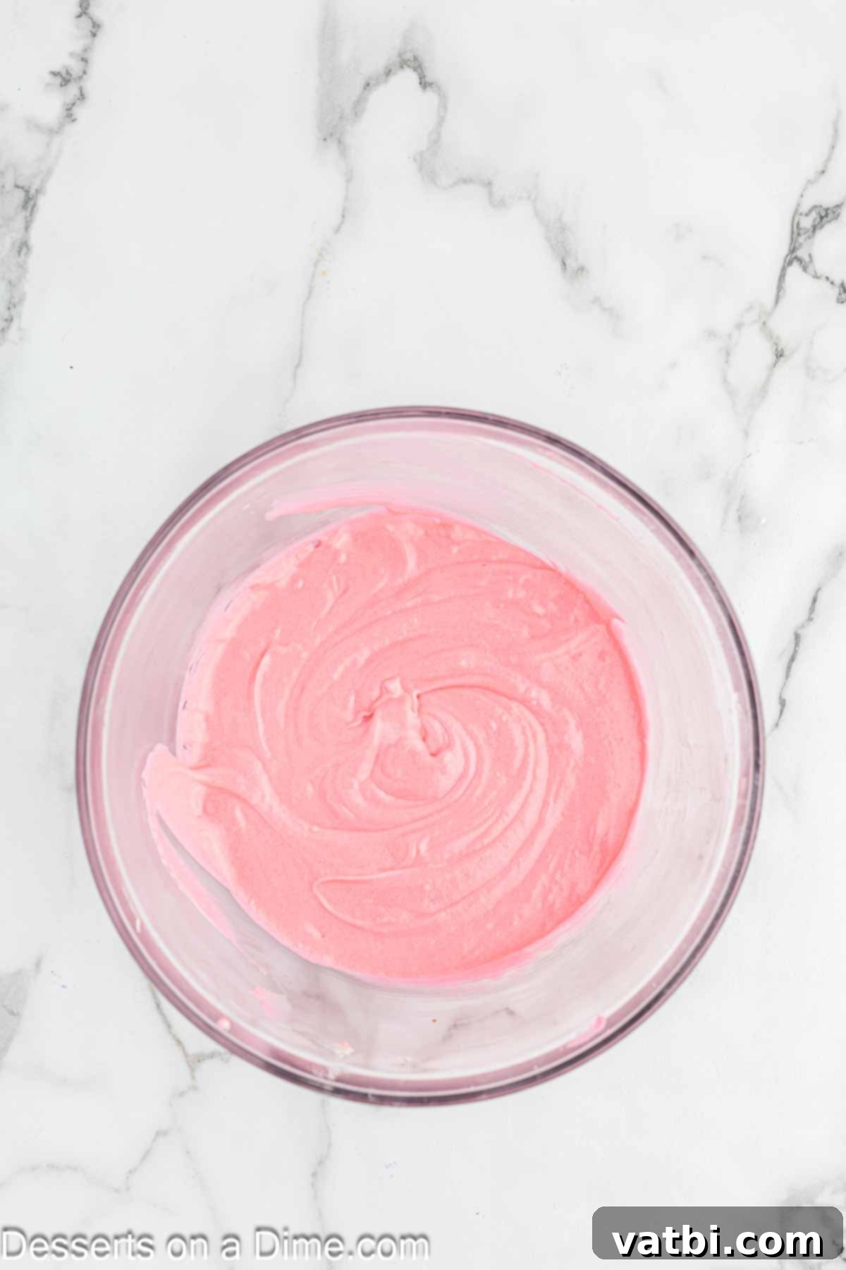 Blushing Velvet Cupcakes 7 Pink food coloring being added to the cupcake batter in a bowl.