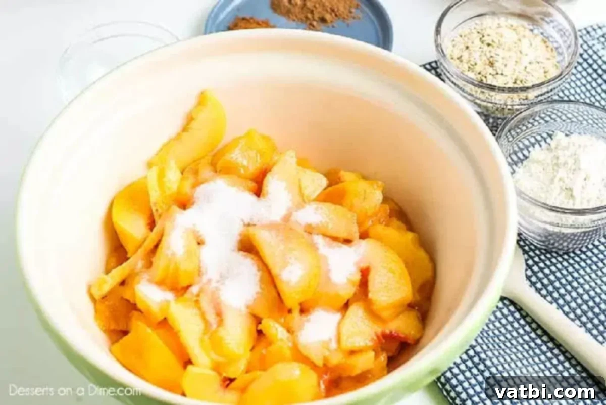 Irresistible Peach Crisp 2 Bowl of freshly peeled and sliced peaches with lemon juice and sugar.