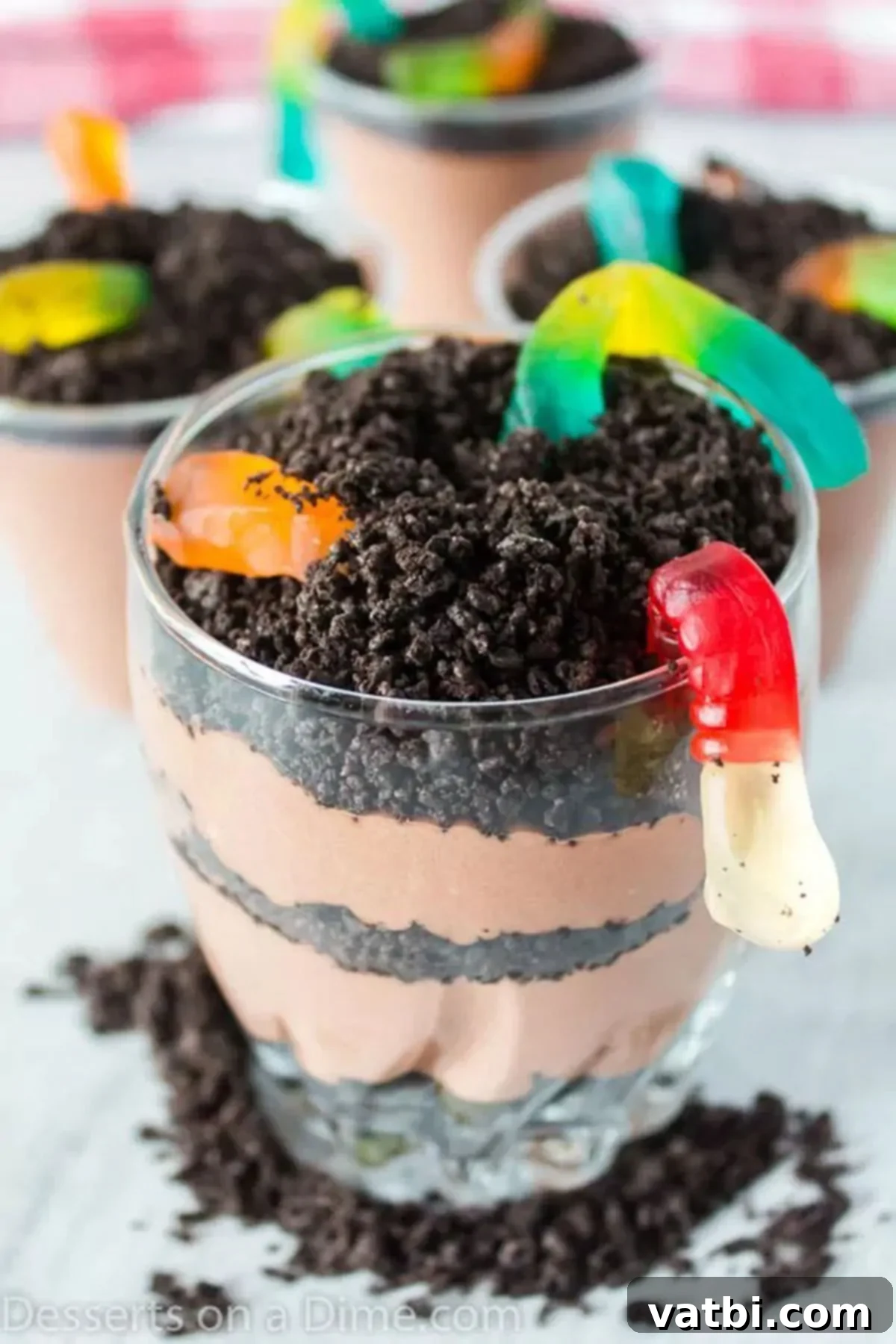 Kids will go crazy over this easy dirt cups recipe. Layers of pudding and oreo cookies topped with gummy worms make an easy treat for kids. Learn how to make individual oreo dirt cup recipe for the best oreo recipe. #dessertonadime #dirtcupsrecipe #halloween #puddings #oreodirtcup Delicious individual dirt cups with layers of chocolate pudding, crushed Oreos, whipped cream, and vibrant gummy worms, ready to be served at a party.