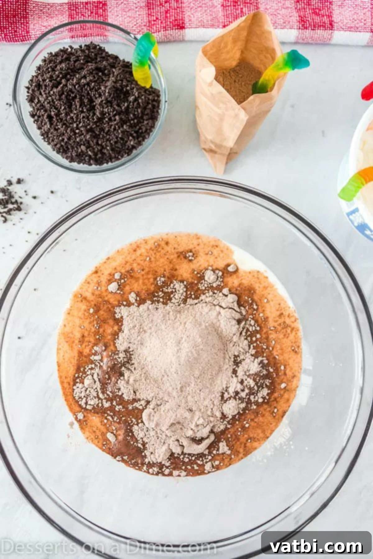 Ultimate Dirt Cup Delight 2 A bowl with chocolate pudding mix and milk being whisked together until smooth and fully combined.