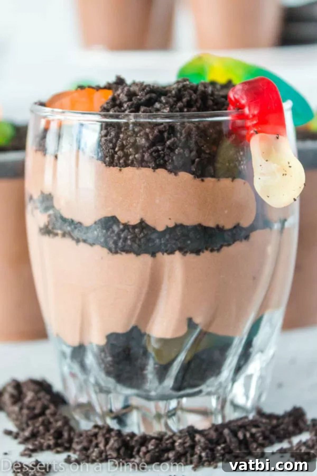 Ultimate Dirt Cup Delight 5 Completed dirt cups, beautifully layered with pudding and crushed Oreos, topped with vibrant gummy worms.