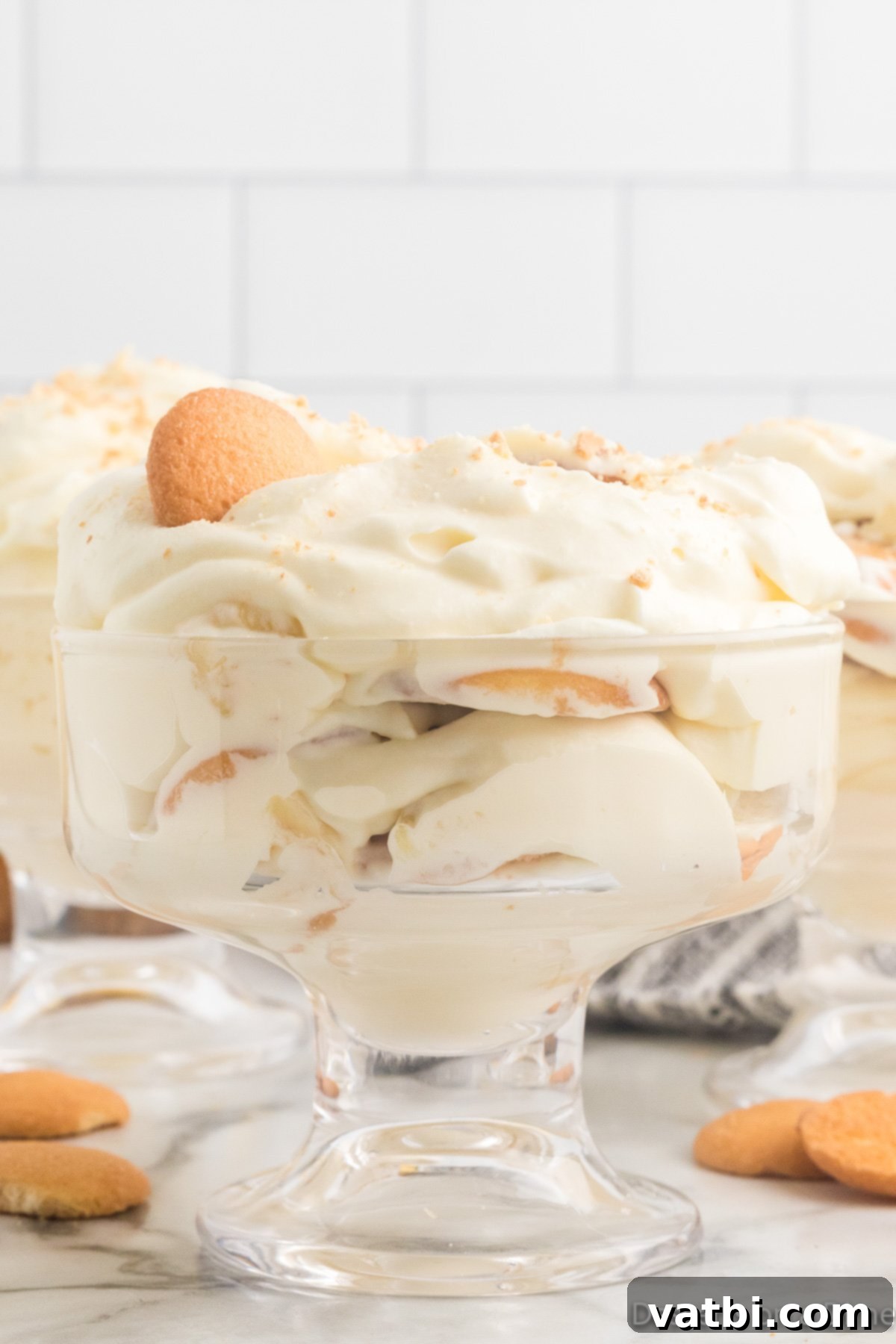 The Ultimate Magnolia Bakery Banana Pudding 2 Glass dish with Magnola banana pudding, showing layers of pudding, bananas, and vanilla wafers.